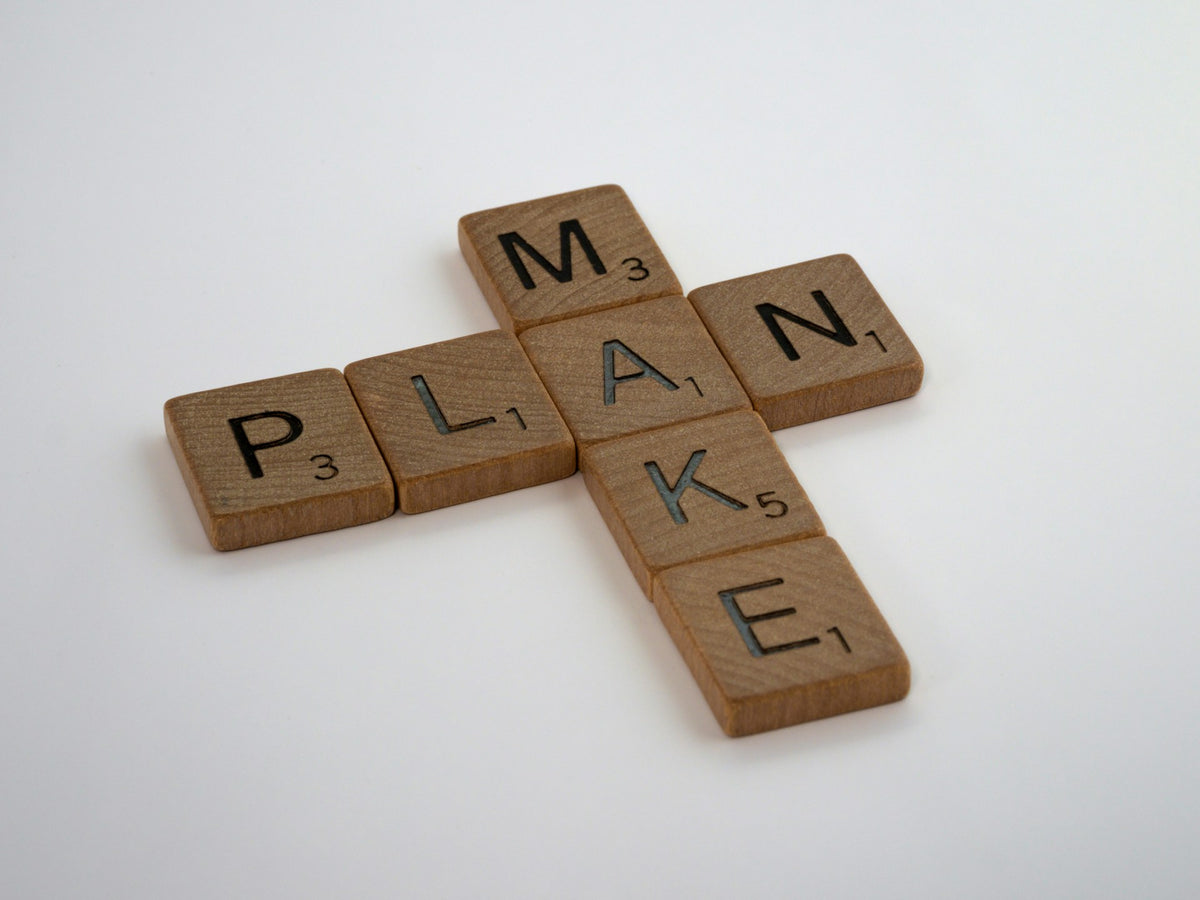 Wortspiel aus ‚PLAN‘ und ‚MAKE‘ im Scrabble-Stil als Symbol für die Verbindung von Planung und Umsetzung