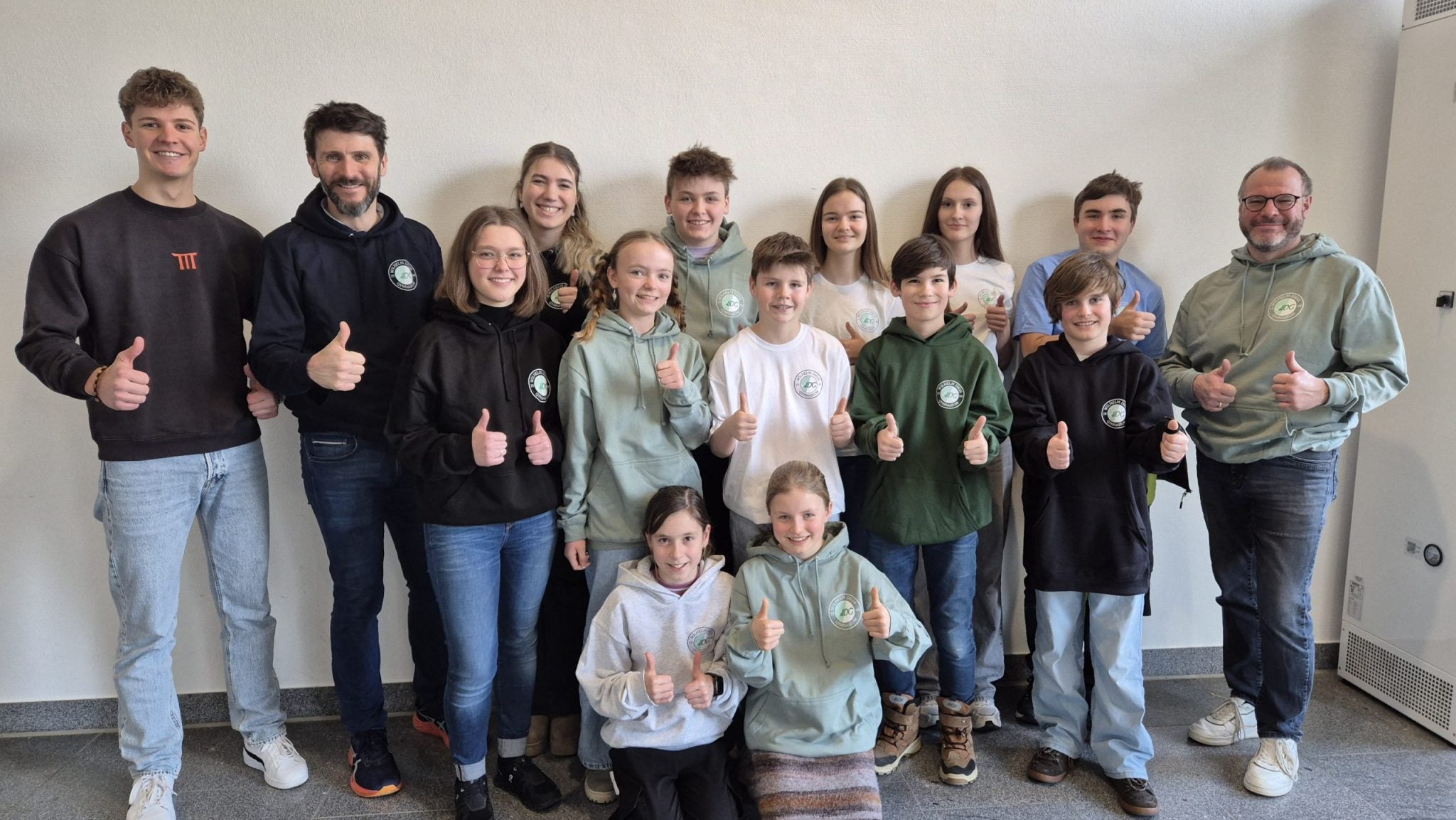 Gruppenfoto von Schülern und Lehrern in moderner Schulkleidung.